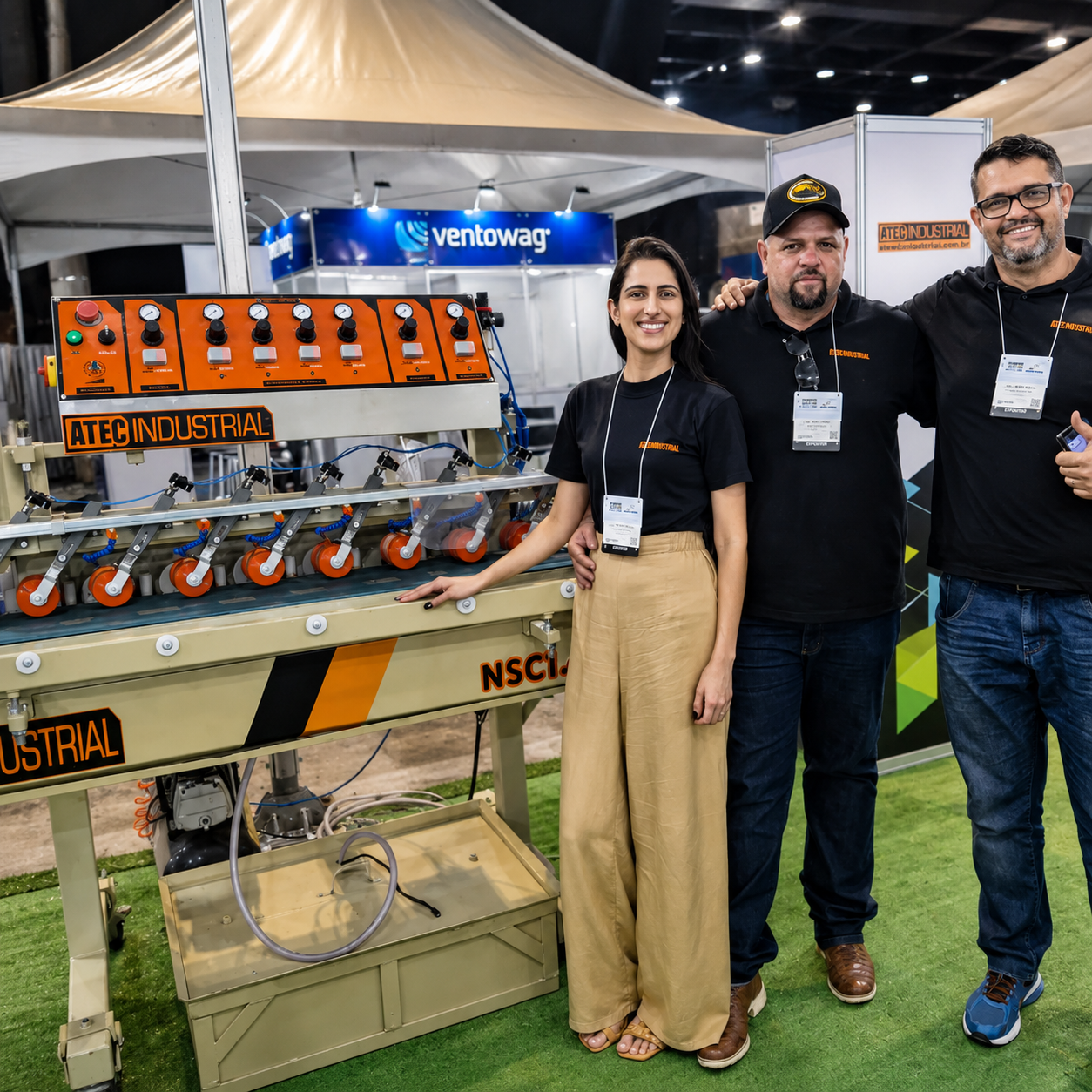 Equipe ATEC Industrial ao lado de equipamento em feira